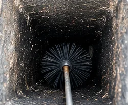 Chimney being swept to remove soot and debris